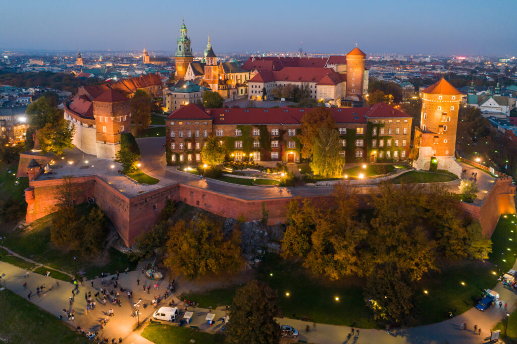 Zamek Królewski na Wawelu o zmierzchu, widok z lotu ptaka z oświetleniem murów