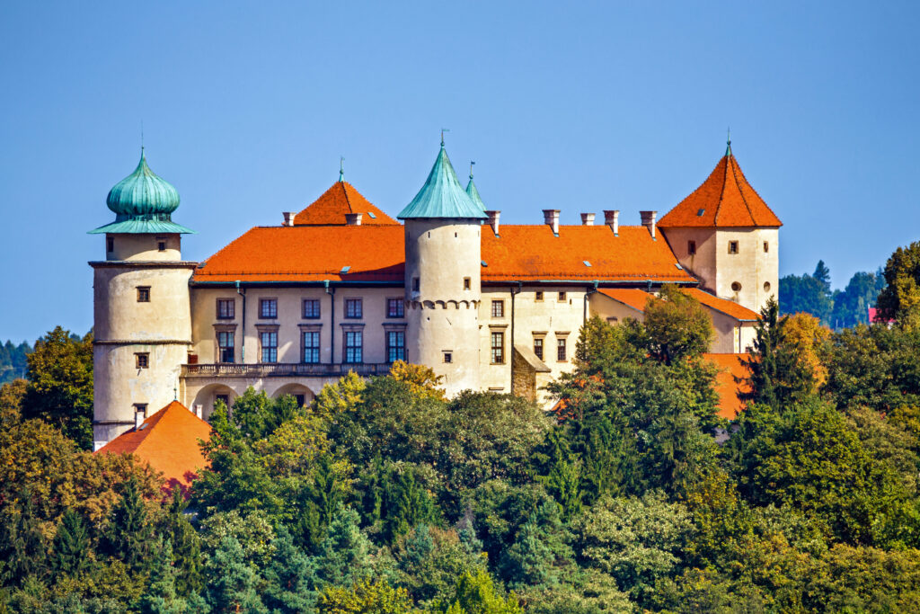 Zamek w Wiśniczu z czerwonym dachem i zielonymi wieżami