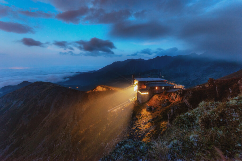 Kasprowy Wierch o zmierzchu z oświetlonym schroniskiem i górską drogą