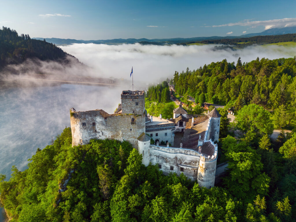 Zamek w Niedzicy o poranku, widok z lotu ptaka nad jeziorem we mgle