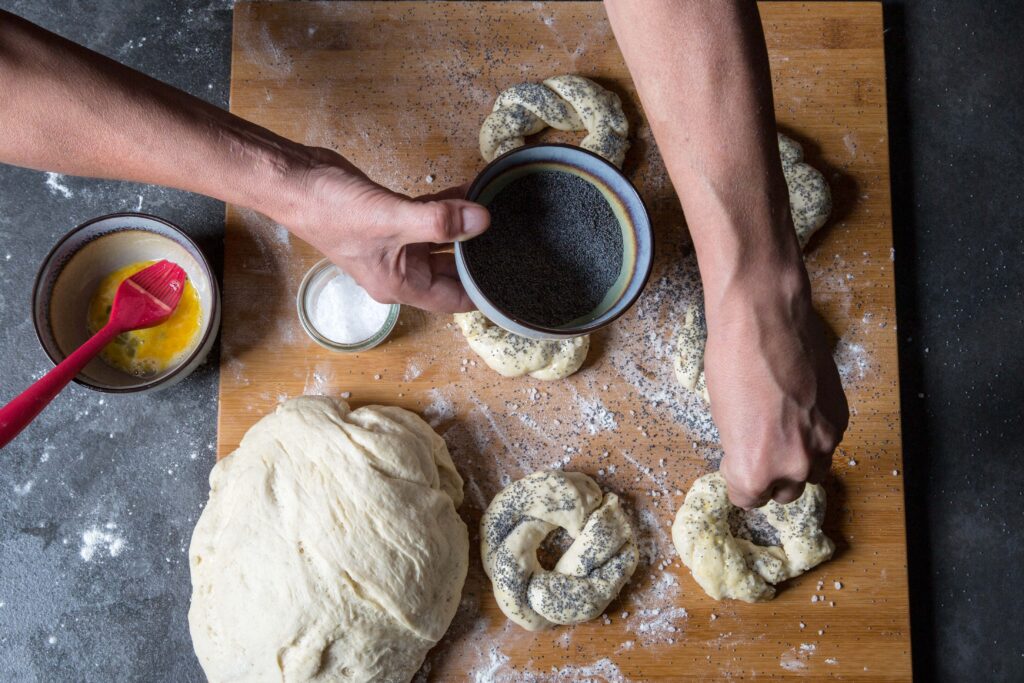 Proces tworzenia obwarzanka krakowskiego z miodowym masłem, ogórkiem i miętą