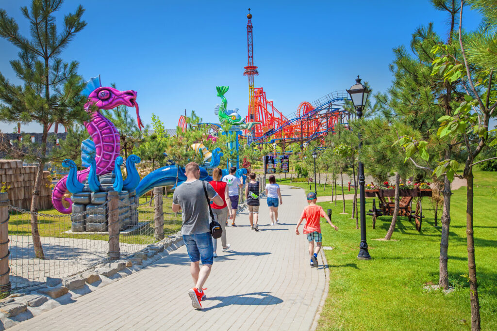 Rodziny spacerujące w kolorowej strefie dziecięcej parku rozrywki Energylandia