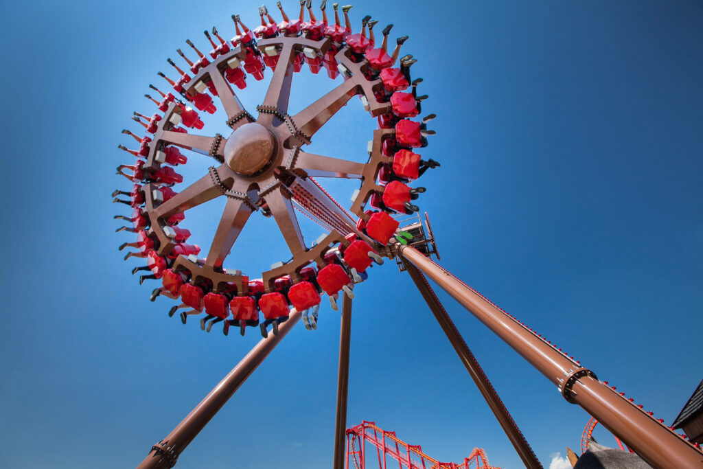 Karuzela obracająca się pionowo z pasażerami na czerwonych siedzeniach w Energylandii